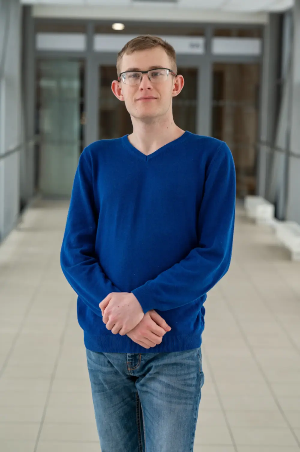 Fotografie Ondřeje Valáška (Textová tapiserie) v riflích a tenkém modrém svetru.